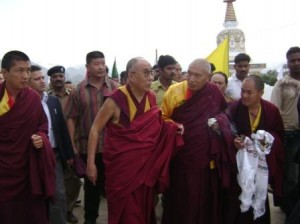His Holiness, His Eminence Namkha Drimed Rinpoche (to his left) and Gyetrul Jigme Rinpoche (to his right) lead the entourage past a complex of stupas at the entrance to the local Tibetan settlement that surrounds Rigon Thupten Mindroling Monastery.