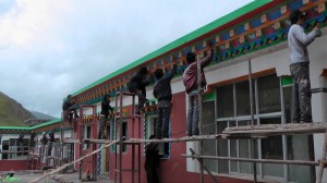 Tibetan painters at work on shedra exterior