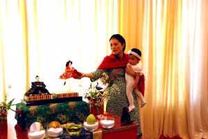 The Sakyong Wangmo, with Jetsun Yudra at her side, places the Queen next to the King doll on the Children’s Day shrine.